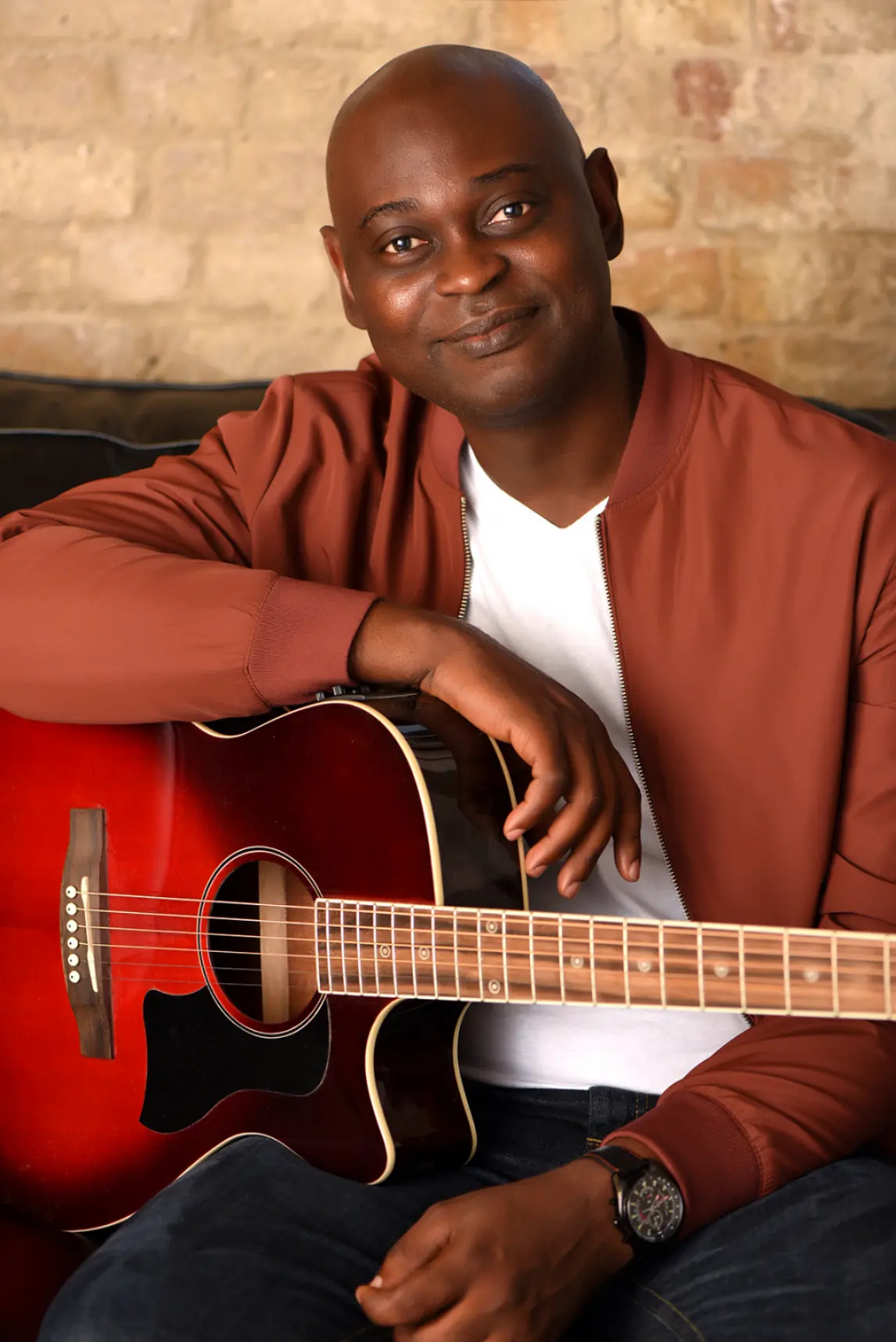 Yemi Alafifuni with an acoustic guitar, photographed in August 2020